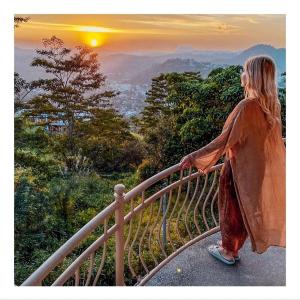 a woman standing on a railing watching the sunset at The Manor Hanthana in Kandy +31 photos