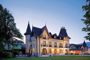 une grande maison avec une tourelle dans l'établissement Le Manoir d'Agnès, à Tarascon-sur-Ariège