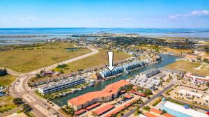 una vista aerea di una città con una freccia bianca di Spinnaker 317 - WATERFRONT BOAT SLIP a Padre Island