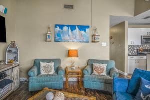 un soggiorno con due sedie blu e un tavolo di Spinnaker 317 - WATERFRONT BOAT SLIP a Padre Island