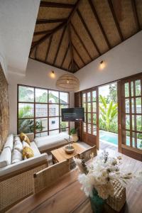 a living room with a couch and a table at Villa Taman & Villa Serai Kedungu in Tanah Lot