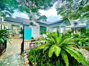 a white house with a fence and plants at Rosie Garden & Home in Na Jomtien