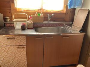 eine Küche mit Spüle und Theke in der Unterkunft コテージコッタロ in Gojikkoku