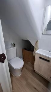 Un baño blanco con inodoro y lavabo. en La casita, en Muros