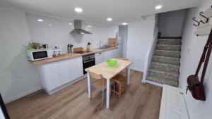 una cocina con mesa y microondas y una escalera en La casita, en Muros
