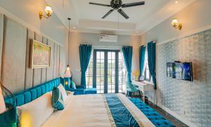 a bedroom with a bed and a ceiling fan at Vườn Vua Resort & Villas in Ðồng Phú +12 photos