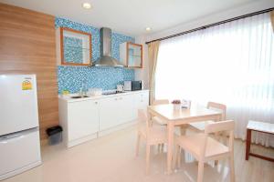 a kitchen and dining room with a table and a refrigerator at The Sea Condominium A16 @ Dophin Bay, Pranburi in Ban Nong Khaem