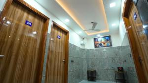 un bagno con 2 porte in legno e una doccia di Skymax hotel a Nuova Delhi