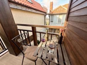 - Balcón con mesa de madera y botella de vino en Arthotel Oscar I Sozopol, en Sozopol