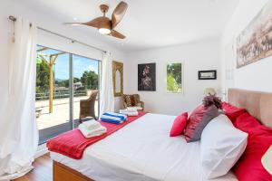 a bedroom with a large white bed with red pillows at Villa Tesoro in El Toro +31 photos