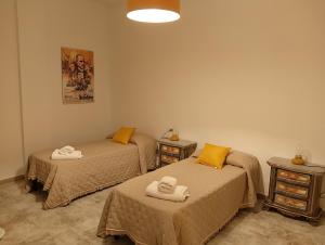 a room with two beds with towels on them at John's House in Sanremo
