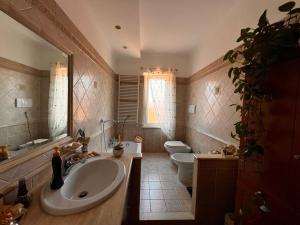 Un baño con lavabo, inodoro y espejo. en The green house, en Roma