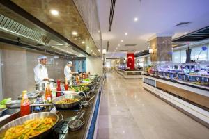 a kitchen with two chefs preparing food in a restaurant at Karmir Resort & Spa - Ultra All Inclusive in Kemer