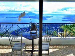 a table with chairs and a vase of flowers on a balcony at Villa Ibarra in Tagaytay +55 photos