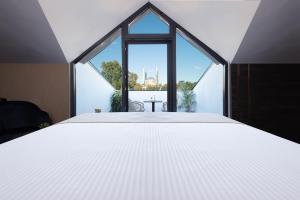 um quarto com uma cama grande e uma janela grande em WestDoor Hotel em Edirne