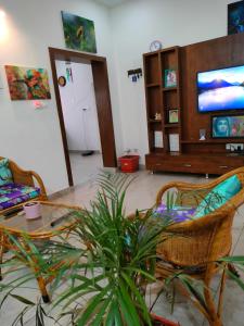 a living room with a table and chairs and a tv at Just for women homestays in Chikmagalūr +51 photos