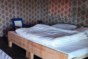 a bed with a wooden frame in a bedroom at Camping at Snow Adventure Camps in Ukhimath