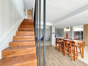 - une salle à manger et une cuisine avec une table en bois et des escaliers en bois dans l'établissement RedDoorz Syariah Near Maguwoharjo Yogyakarta, à Seturan