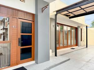 une paire de portes en bois sur une maison dans l'établissement RedDoorz Syariah Near Maguwoharjo Yogyakarta, à Seturan