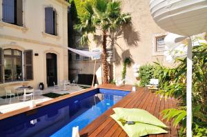 einen Hinterhof mit einem Pool und einem Haus in der Unterkunft L'Hôtel Particulier Beziers in Béziers