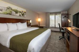 a hotel room with a large bed and a desk at Comfort Inn in Sault Ste. Marie