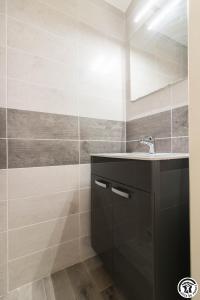 une salle de bain avec un lavabo et un miroir dans l'établissement Les Villas de Castel - Villa Les lauriers, à Castelmaurou 27 autres photos