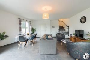 un salon avec un canapé, une table et des chaises dans l'établissement Les Villas de Castel - Villa Les lauriers, à Castelmaurou