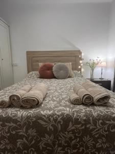 a bed with pillows and blankets on top of it at Rincón de María - Ganador Traveller Awards 2025 y 2026 in Playa de Gandia