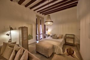 una camera da letto con un letto e un divano in una stanza di Can Savella - Turismo de Interior a Palma de Mallorca