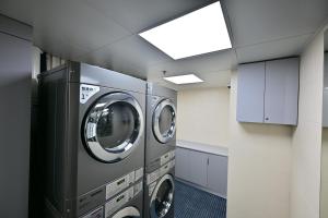 two washing machines are in a laundry room at Novotel Atlantis Shanghai - Enjoy our great-valued breakfast in our rooftop revolving restaurant with a stunning river view & utilize our FREE self-serviced laundry in Shanghai