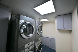 a laundry room with two washing machines in it at Novotel Atlantis Shanghai - Enjoy our great-valued breakfast in our rooftop revolving restaurant with a stunning river view & utilize our FREE self-serviced laundry in Shanghai