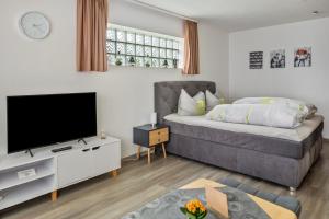 een woonkamer met een bed en een flatscreen-tv bij Haus Sommerberg in Titisee-Neustadt