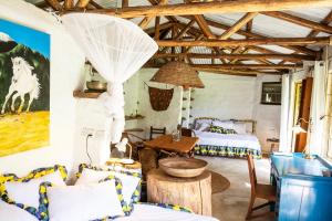 a bedroom with two beds and a table in a room at Hillside Retreat – Africa Amini Life in Usa River
