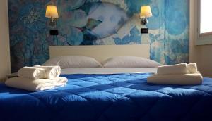 a bedroom with a blue bed with towels on it at Lake Garda Hostel in Salò