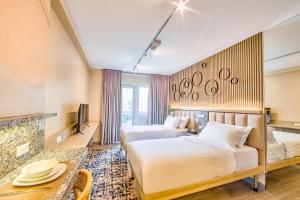 マニラにあるThe Connor Serviced Residences Managed by HIIのベッド2台とテーブルがあるホテルの部屋