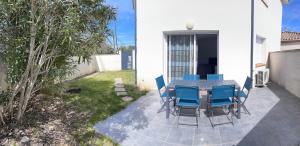 une table et des chaises bleues sur une terrasse dans l'établissement Les Villas de Castel - Villa Les lauriers, à Castelmaurou