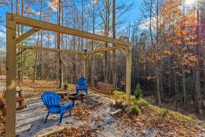 two blue chairs and a pergola in the woods at EagleRock Retreat in Rogers