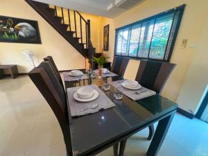 Un comedor con mesa y sillas y una escalera. en Baan Chai Hadd, en Pattaya South