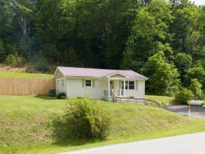 a small house on top of a grassy hill at 50 Shades of Slade in Rogers