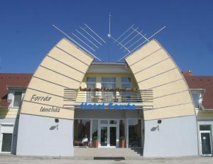 un bâtiment avec un grand bâtiment avec trois grandes flèches dans l'établissement Hotel Forras, à Komárom