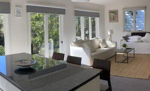 Una cocina y una sala de estar con un sofá y una mesa. en Auckland Bungalow Apartment, en Auckland