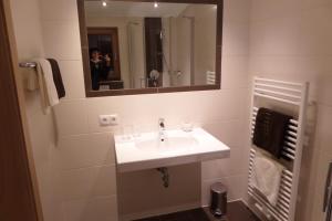 Un baño con un lavabo blanco y un espejo. en Landhaus Noal, en Mayrhofen
