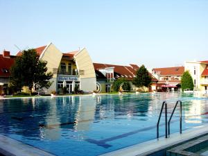 a large swimming pool in front of a building at Hotel Forras in Komárom