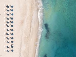 an overhead view of a beach with a group of umbrellas at Grecotel Plaza Beach House in Rethymno Town