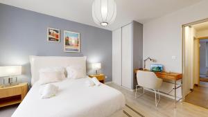 a bedroom with a large white bed and a desk at expat renting - Le Volta - Terrasse - Netflix in Toulouse