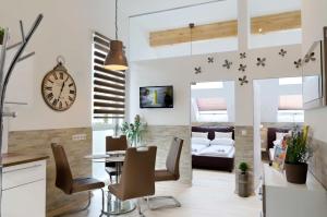 comedor y sala de estar con reloj en la pared en Flatprovider - Manuela Apartment Vienna, en Viena