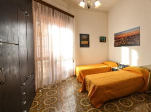 Un dormitorio con dos camas y una ventana. en Casa Francesco, en Quartu SantʼElena