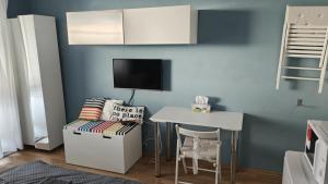 a small room with a table and a tv on a wall at Útulná Garsónka 5 in Vranov nad Topľou