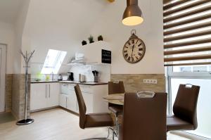 a kitchen with a table and a clock on the wall at Flatprovider - Manuela Apartment Vienna in Vienna