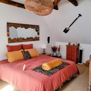 a bedroom with a bed with a red bedspread at Le Manoir des Pélies Gîte et Chambres d'hôtes de charme à 7kms de Conques Spa, Piscine, Rivière, Thermes de Cransac in Conques